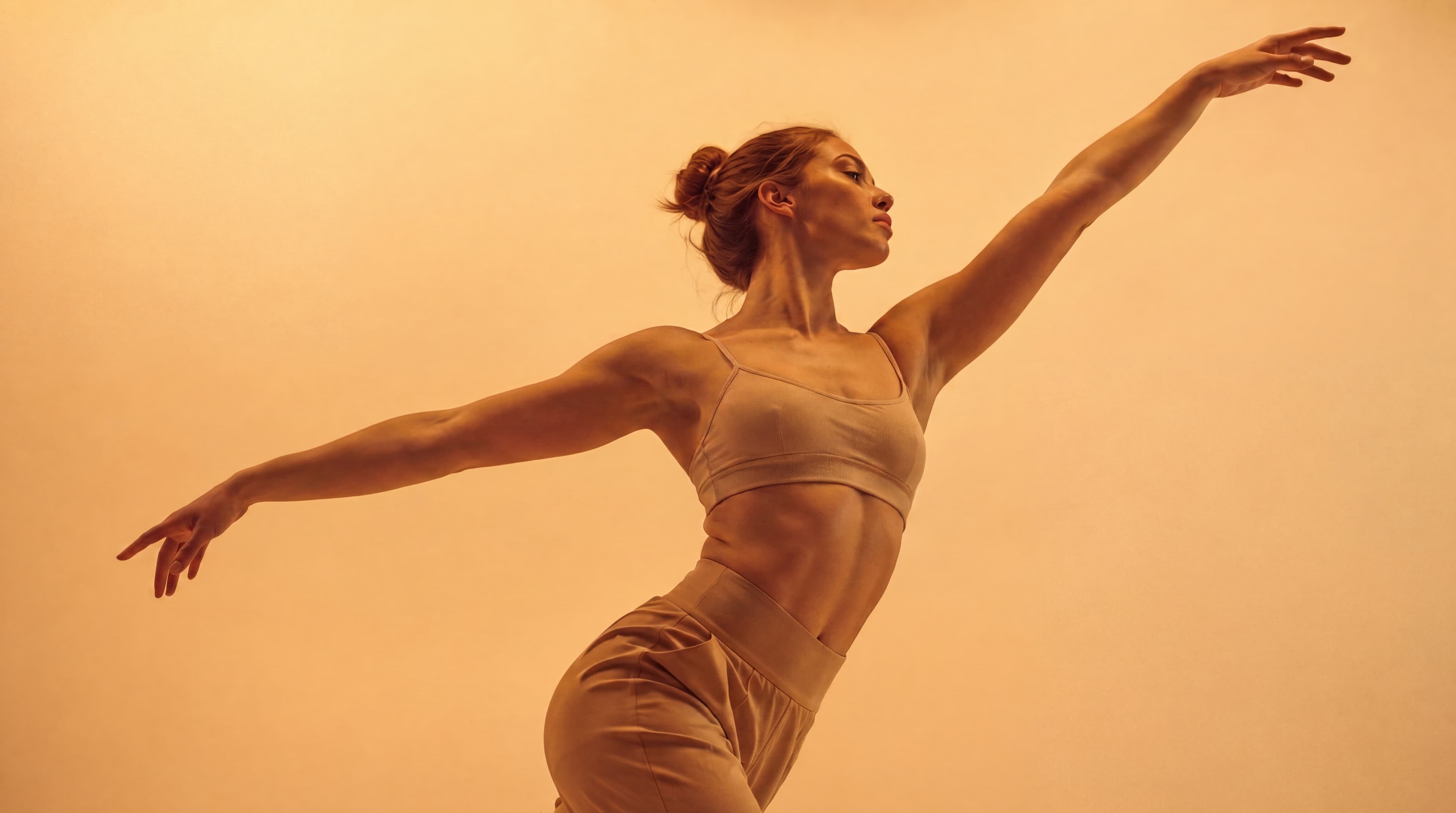Dancer reaching outward in warm amber light